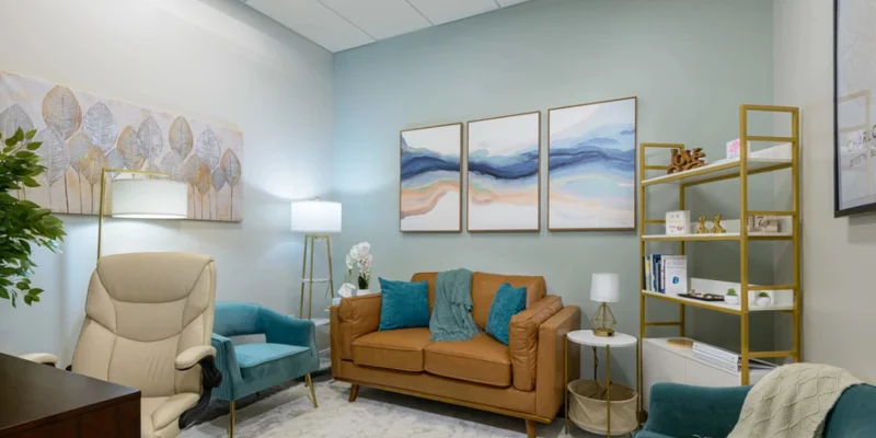 Therapy room with a couch and desk.