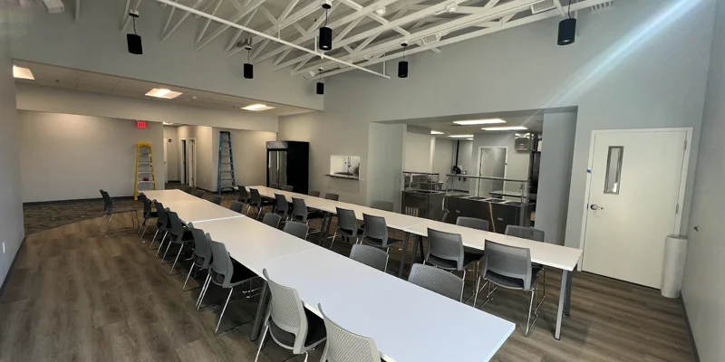 Dining area with tables, seating, and a fridge.