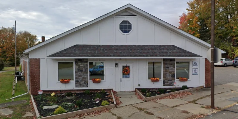 Main entrance with stone accents, planters, and seasonal décor