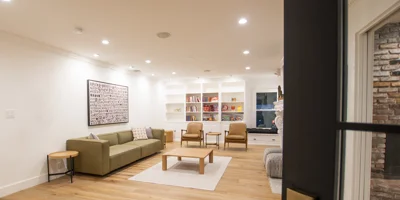 A bright common area with bookshelves, games, and seating.