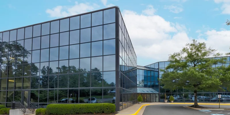 Facility exterior with trees and a parking lot outside.