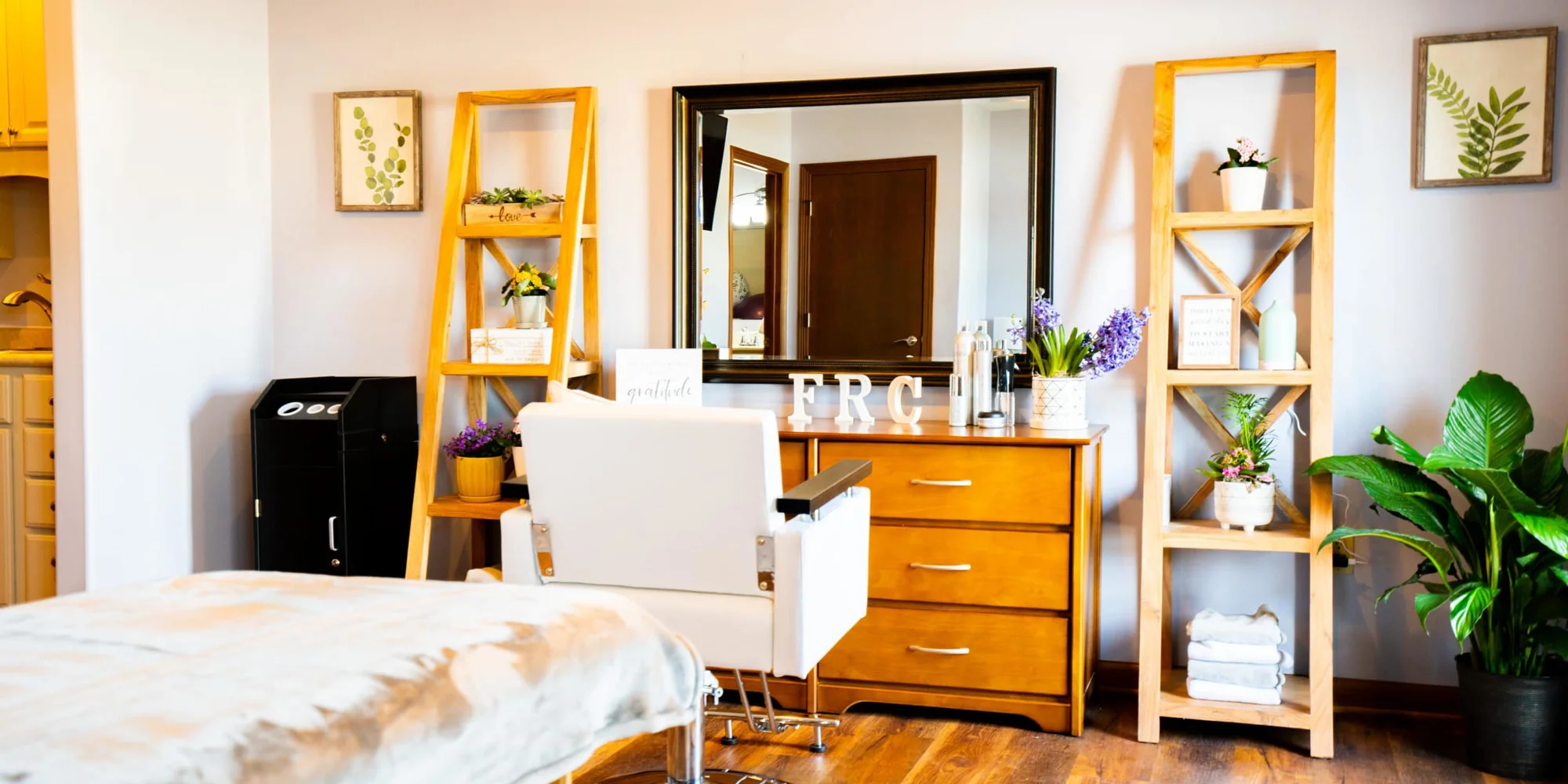  A wellness room with a salon chair, mirror, and plants.