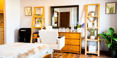  A wellness room with a salon chair, mirror, and plants.