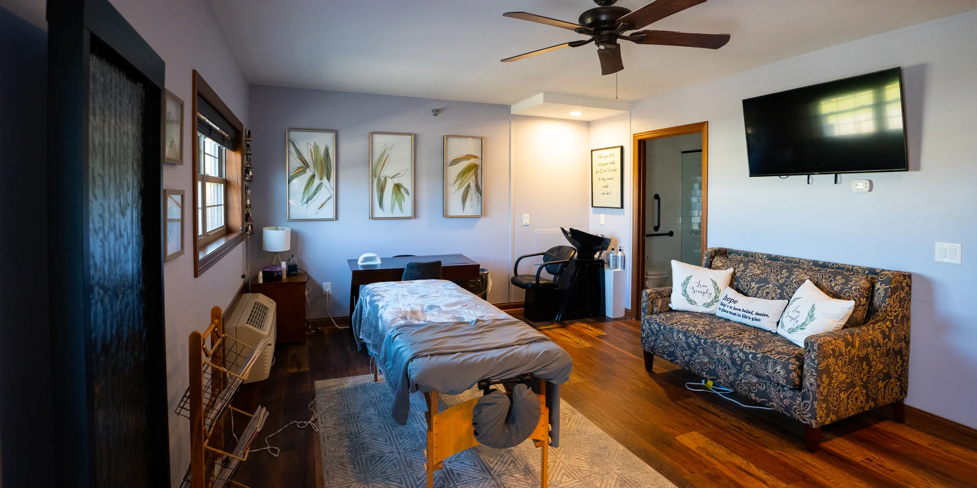 Massage room with spa table, art, and salon chair