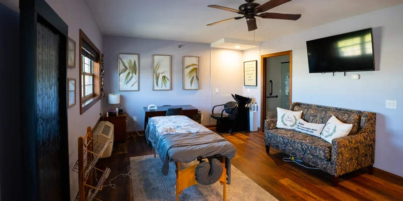 Massage room with spa table, art, and salon chair