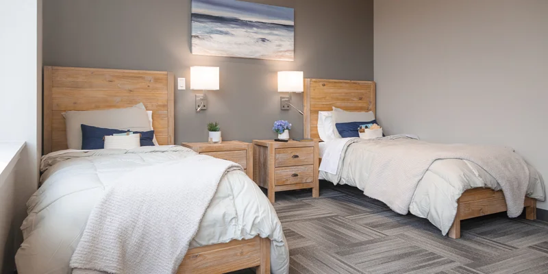 Cozy rehab facility bedroom with twin beds and wooden furniture.