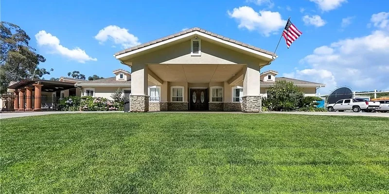 Facility entrance with a lawn and flag.