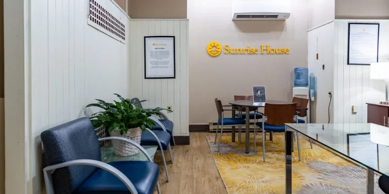 Waiting area at sunrise house with chairs and signage on the wall.