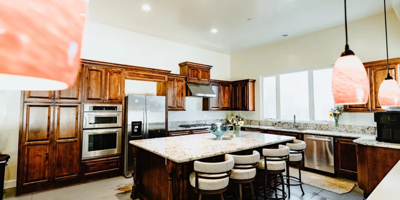 Kitchen with appliances, and an island with seating.