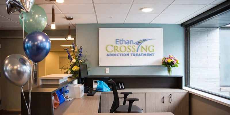 A reception desk with balloons and an "Ethan Crossing" sign.