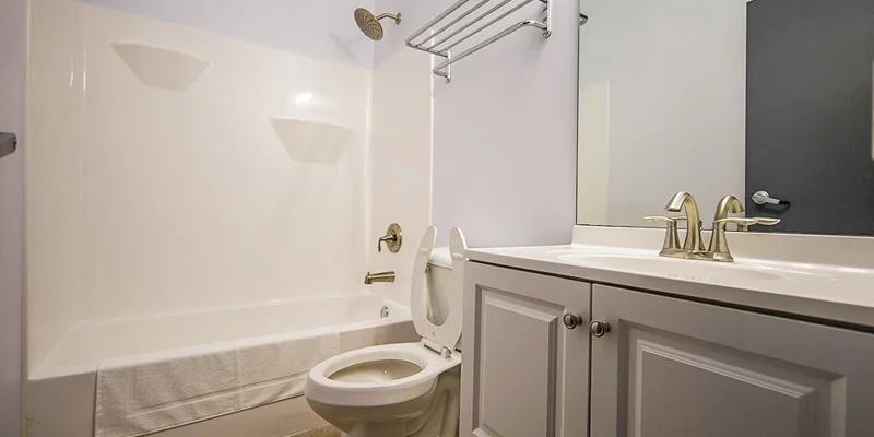 A clean bathroom with a white sink, toilet, and bathtub with a shower.