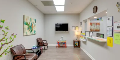 Waiting area with chairs, a reception counter, and a magazine rack.