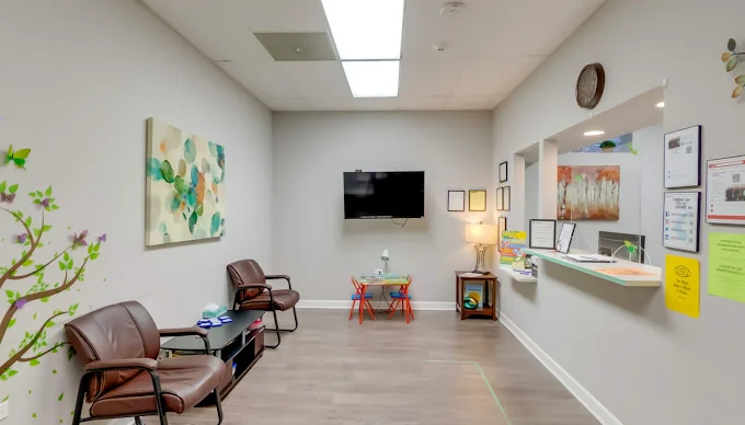 Waiting area with chairs, a reception counter, and a magazine rack.