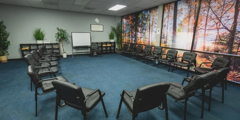 Group therapy room with chairs and whiteboard.