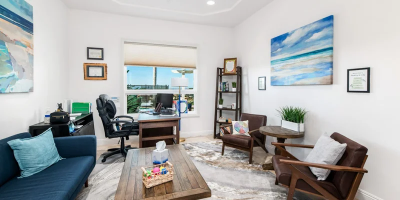 Therapy room with office space and chairs around decor.