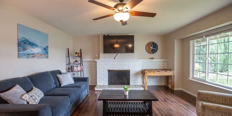 A living space with a fireplace, sofa, and foosball table.