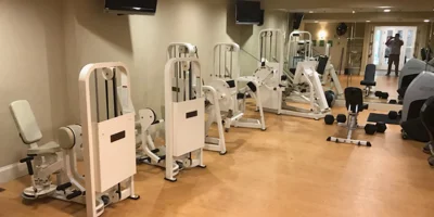 A fitness room with exercise machines and weights.