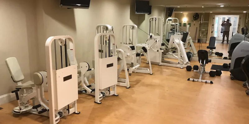 A fitness room with exercise machines and weights.