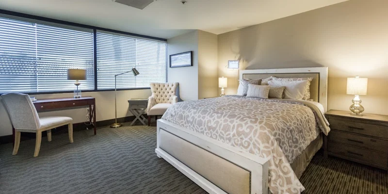 A bedroom with a large bed, desk, and cozy seating area