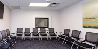 A group therapy room with black chairs and modern decor.