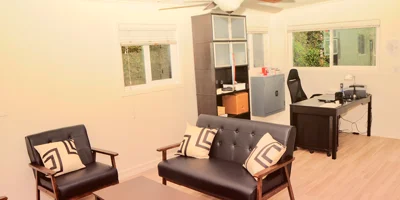 Office space with black leather seating and a desk.