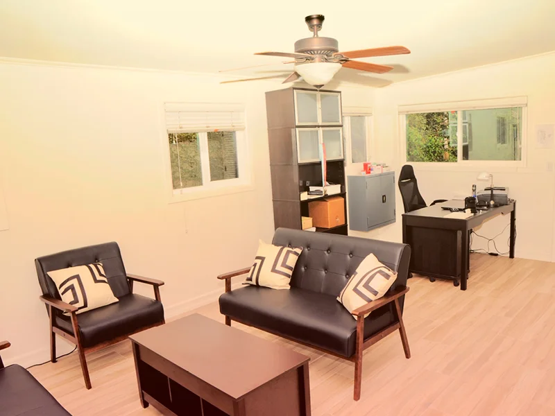 Office space with black leather seating and a desk.