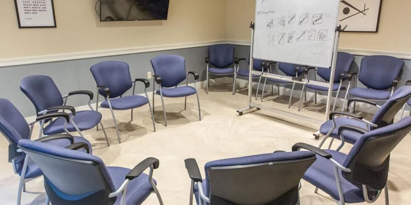 Group therapy room arranged with chairs in a circle.