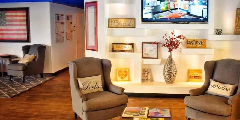 Lounge with chairs and a mounted TV.