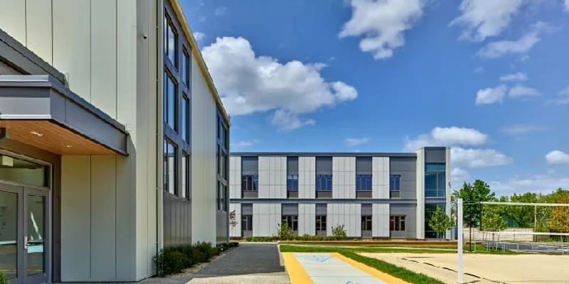 Exterior of facility with walkway and volleyball court nearby.