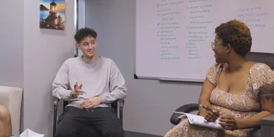 People in a therapy session with whiteboard backdrop.