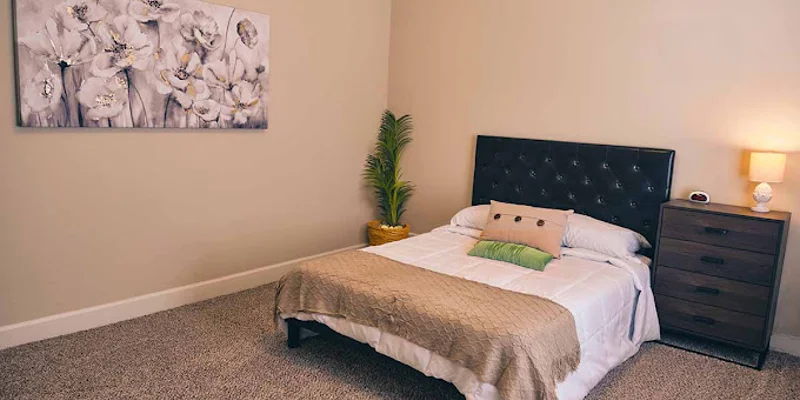 Bedroom with a neatly made bed and wall decor.
