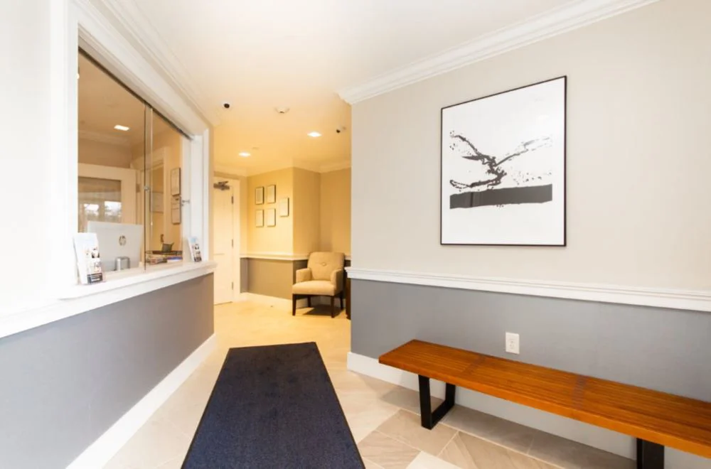 Lobby with  chairs, reception desk window.