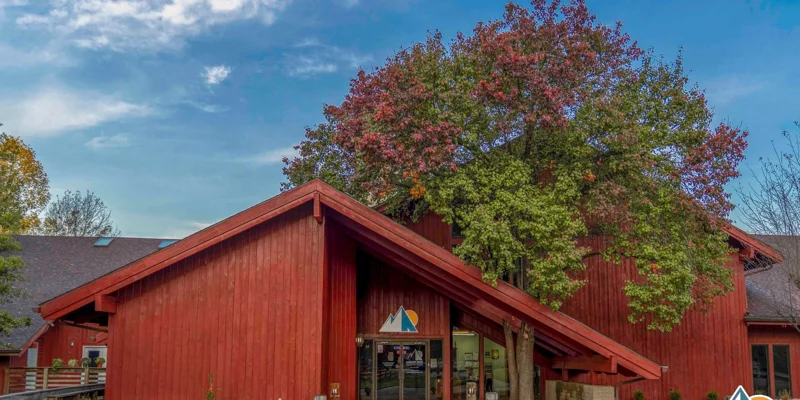 Entrance of a red building with a large tree in front