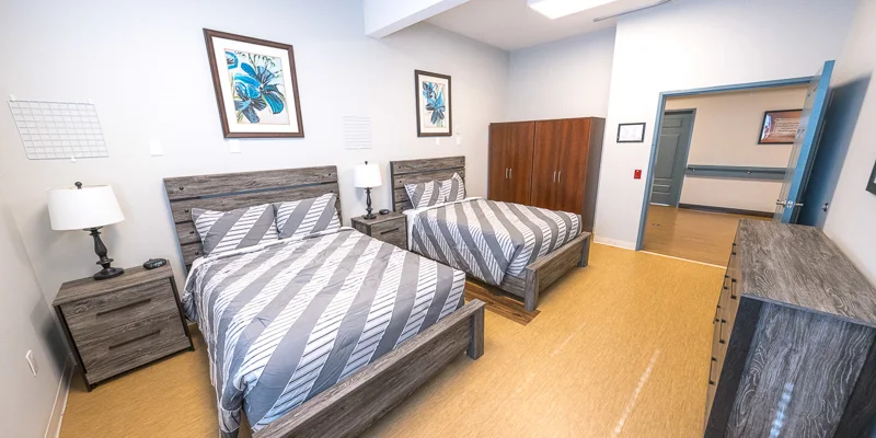 Shared bedroom with two twin beds and a sidetables.
