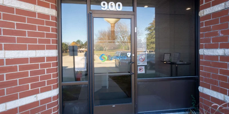 Entrance of a modern center with glass doors and front sign.