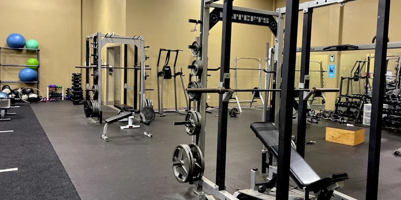  A fitness center with weightlifting equipment and rubber flooring