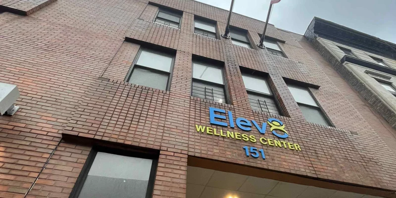 High-rise exterior with signage and street-level entry.