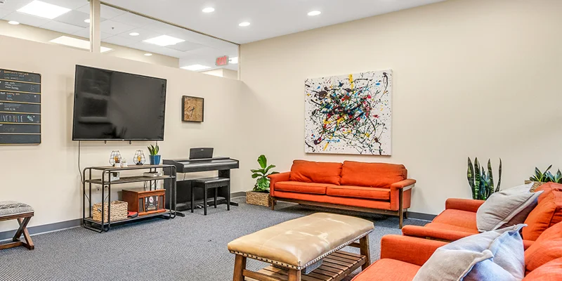 Lounge area with  sofas and a piano.