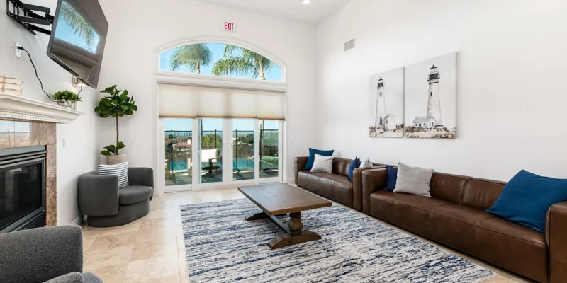 Spacious lounge with sofas, TV, fireplace and large windows.