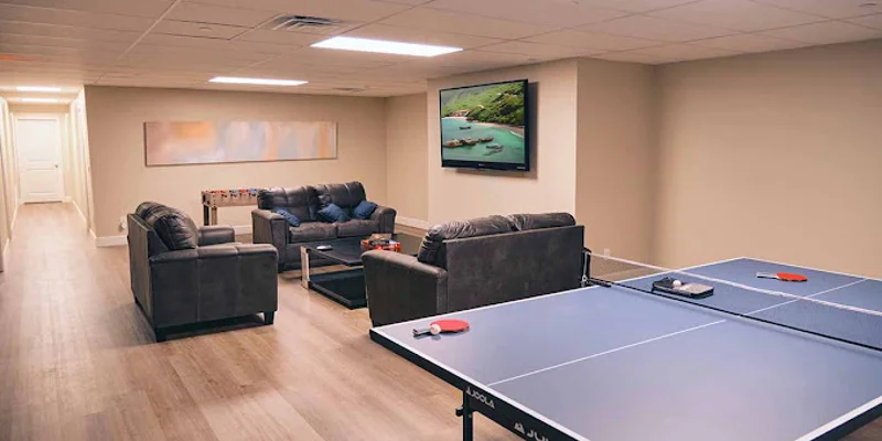 Recreation room with a ping pong table and seating.
