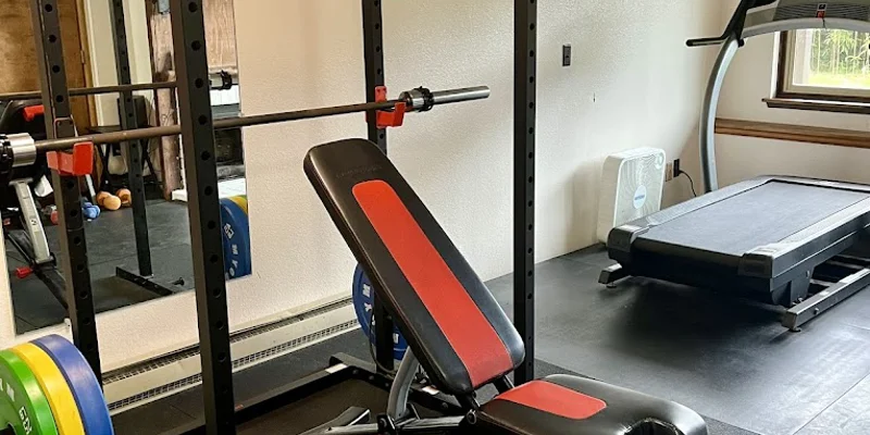 A rehab gym with weightlifting equipment and a treadmill.