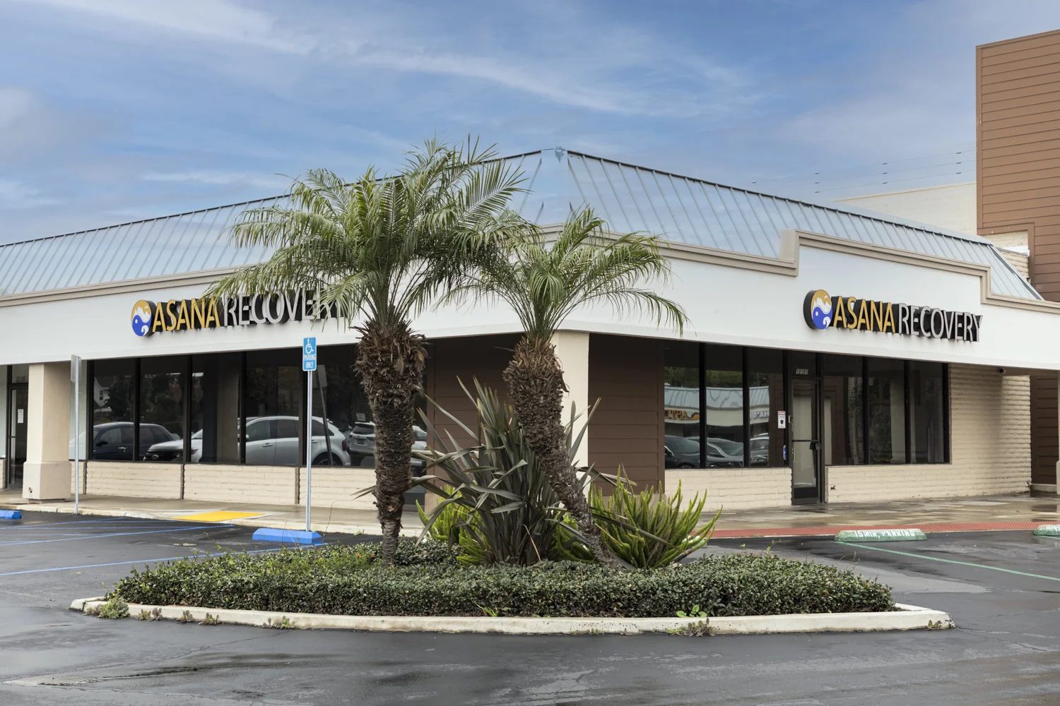 Exterior of Asana Recovery with a modern design and palm trees.
