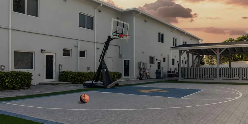 Basketball court with shaded patio area.