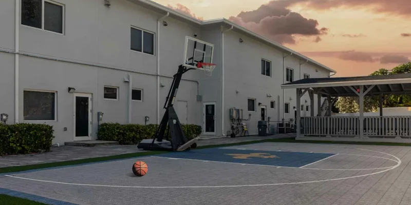 Basketball court with shaded patio area.