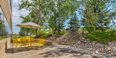 An outdoor seating area with yellow chairs and a patio umbrella.