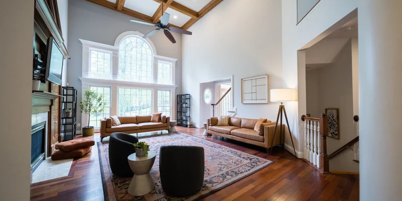 A high-ceiling living room with large windows and elegant furniture 