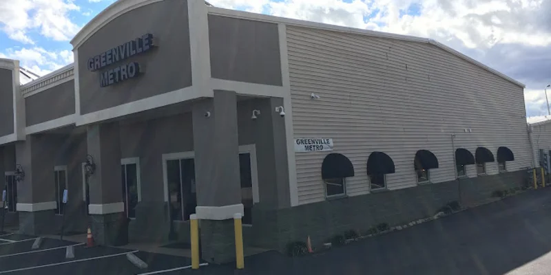 Facility driveway with black awnings and parking.