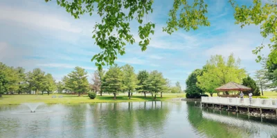 Outdoor area with gazebo, fountain by a pond.