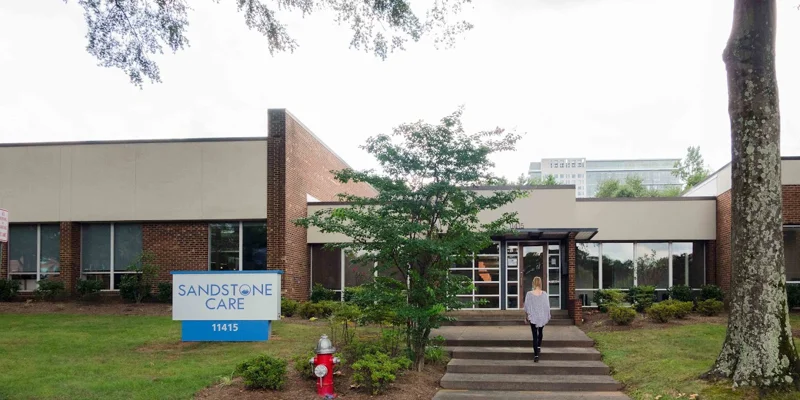 Facility exterior with glass facade and entry walkway.