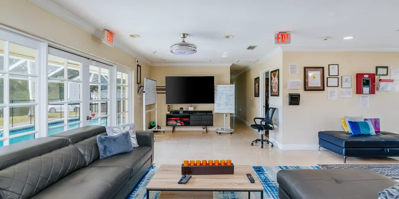 Living room with couches, TV, and whiteboard